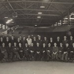 War time photograph of the management team in front of an airframe fabricated on the site